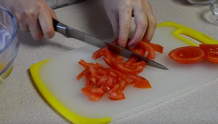 We also cut the tomato into a cube, before removing the soft part of the vegetable.