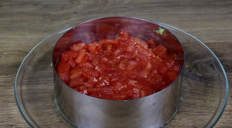Luego, coloque una capa de tomate, sal.