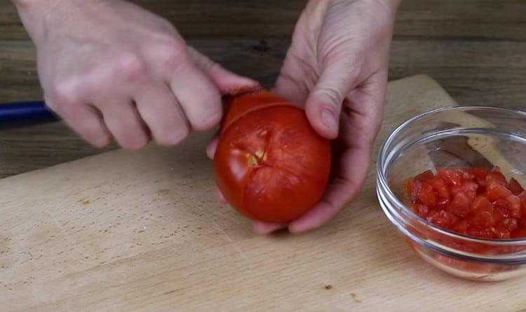 Los tomates se ponen en agua hirviendo durante unos minutos y luego se pelan.