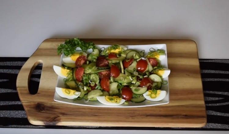 We spread the vegetables on a serving dish, and on top we lay out the pieces of eggs and sprinkle with onions.