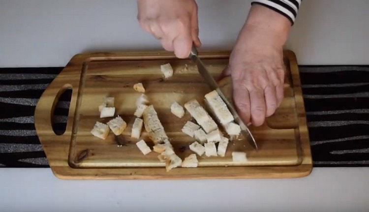 Coupez quelques tranches de pain en petits dés pour faire des craquelins.