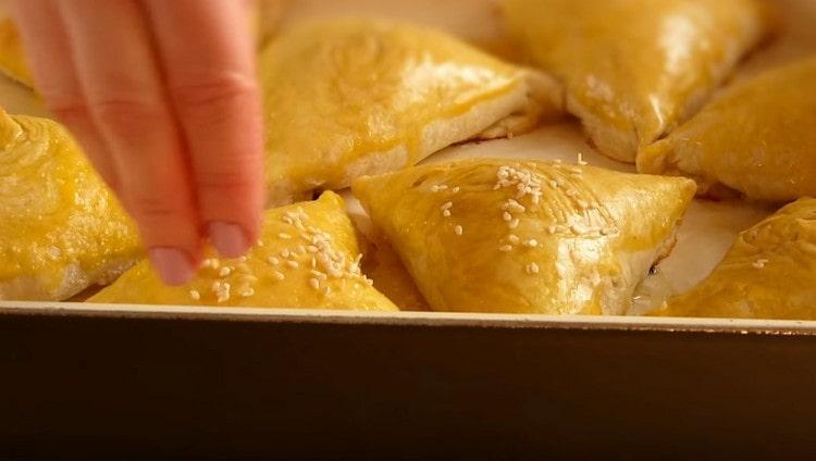 We grease the semi-finished samsa with whipped yolk and sprinkle with sesame seeds.