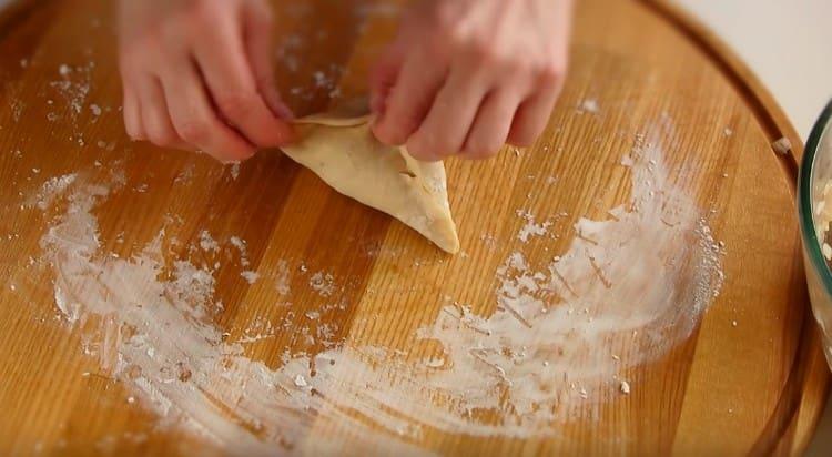 coloca el relleno en el centro del pastel resultante y recoge los bordes de la masa, formando un triángulo.