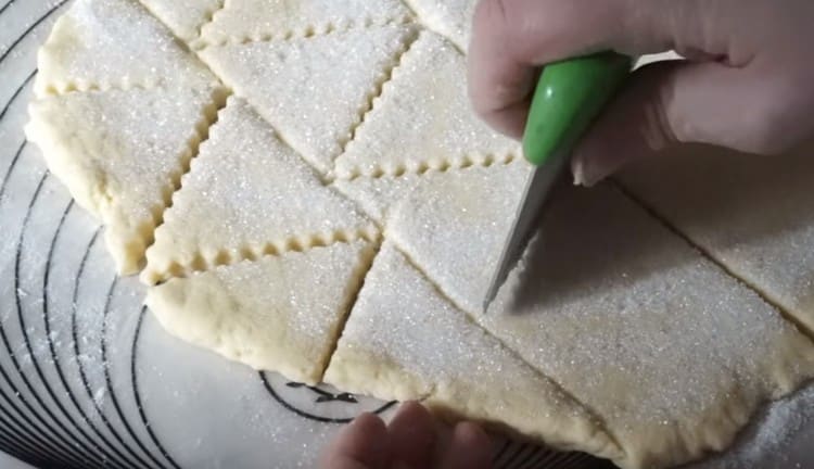 With a curly knife, cut the dough into triangles.