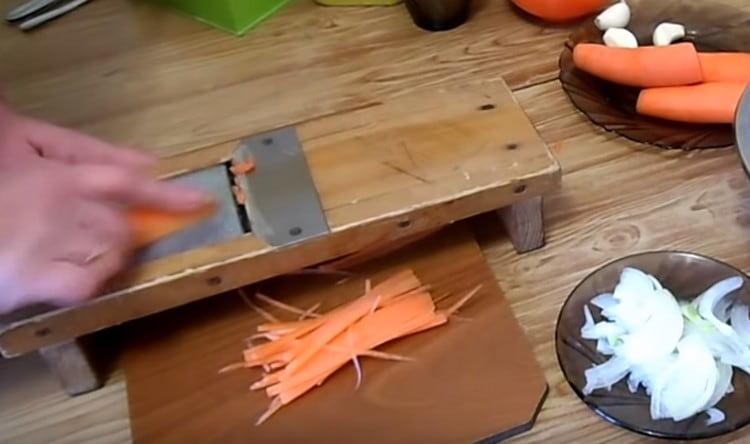 Frota zanahorias en un rallador coreano.
