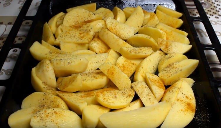 Mettez les pommes de terre sur une plaque à pâtisserie, saupoudrez de sel, de poivre et de curry.