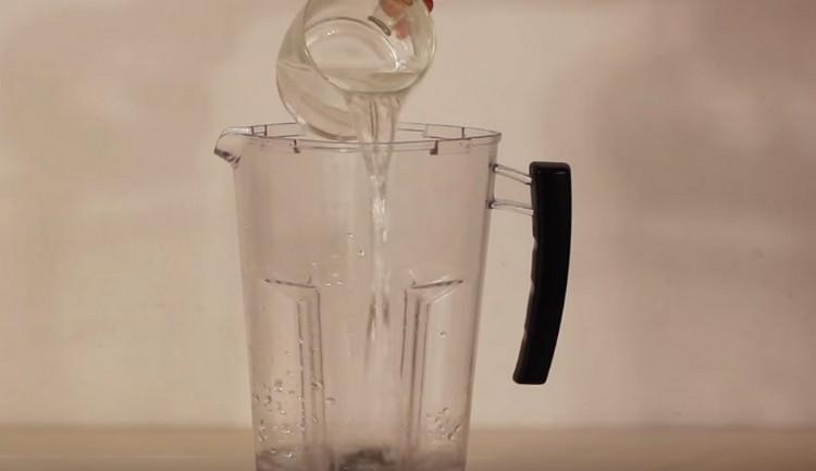 First, pour water into the blender.