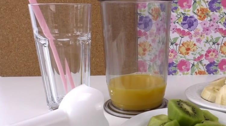 Pour orange juice into the blender bowl.