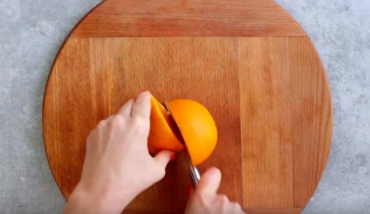 Lavez l'orange et coupez-la en deux.