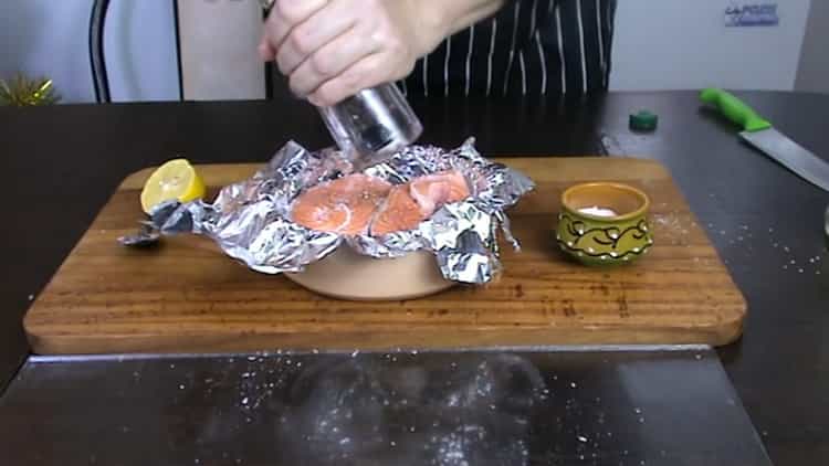 Para cocinar el filete de trucha en el horno, ponga pimienta sobre el pescado.