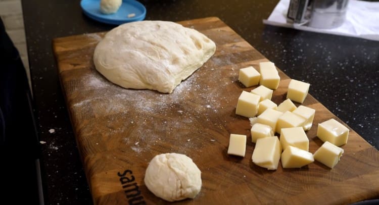 Cheese is cut into large cubes, and the dough is divided into the number of servings corresponding to the pieces of cheese.