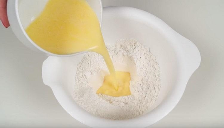 Introduce the liquid components to the flour.