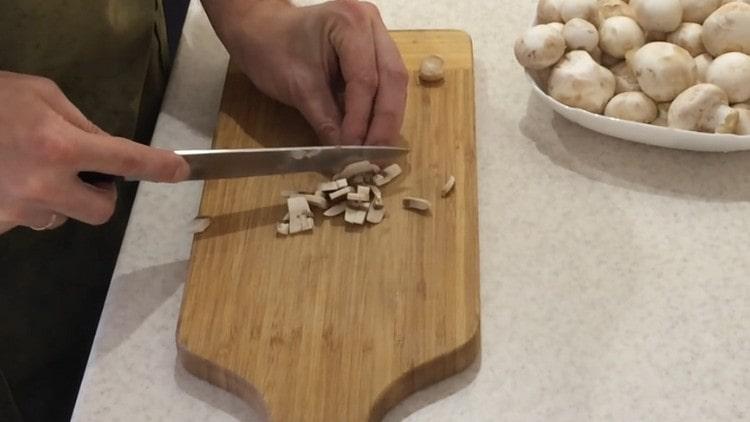 Cortar los champiñones pelados en trozos pequeños.