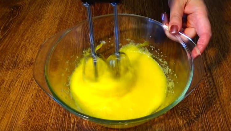 Agregue los huevos al azúcar y bata con una batidora.