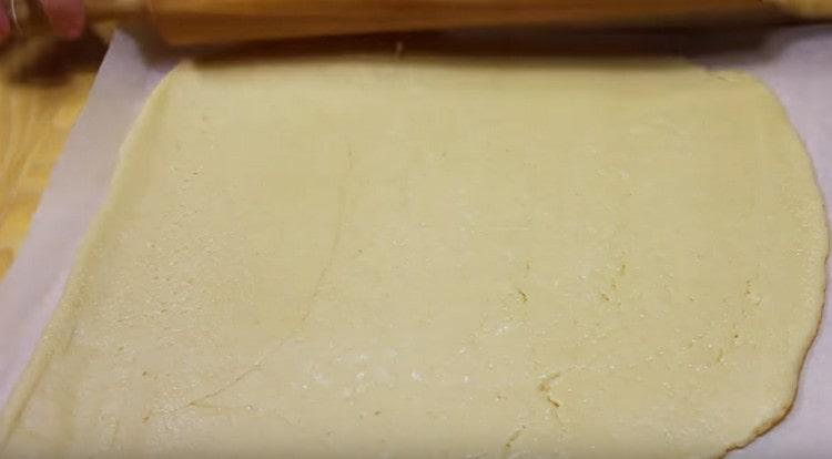 We roll out most of the dough directly on the parchment to the size of the baking sheet.