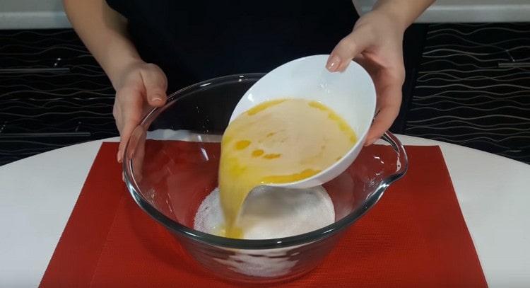 Vierte el azúcar en un tazón y llénalo con mantequilla derretida y ligeramente enfriada.