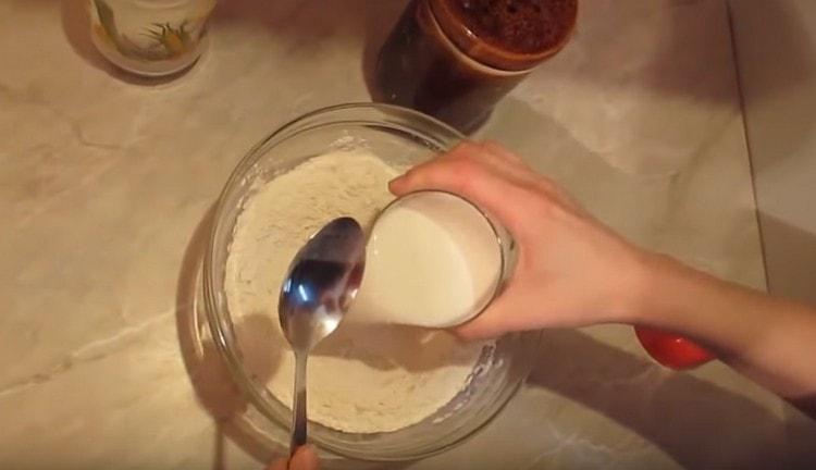 Dodajte mlijeko u brašno i žlicom počnite miješati masu.