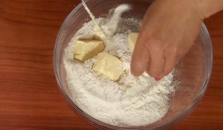 pour flour into a bowl. put slices of cold butter in it.