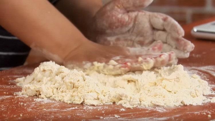 Versez un mélange de farine et d'huile sur la surface de travail et, en ajoutant progressivement de l'eau, frottez-le avec le dos de la main.