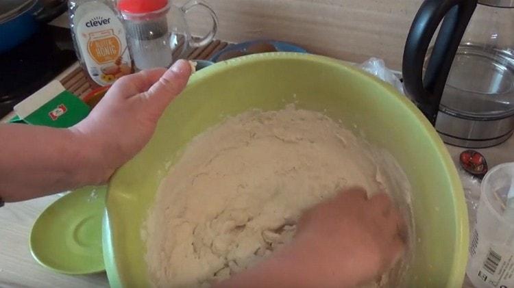 Tout d'abord, pétrir la pâte avec une cuillère, puis pétrir avec les mains.