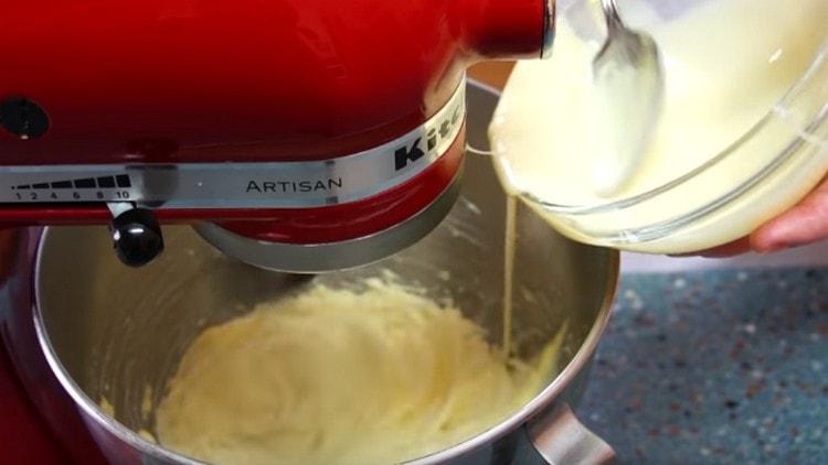 Tukući maslac, postepeno dodajte kondenzirano mlijeko.