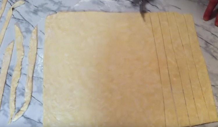 Cut a layer of dough into strips of the same length.