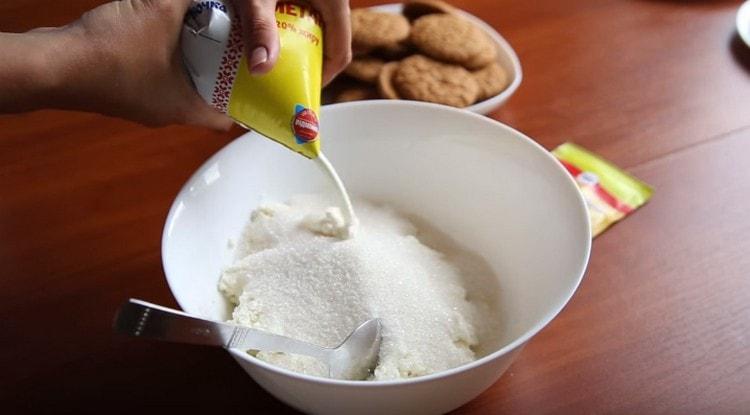 En un recipiente hondo combinamos requesón, azúcar, azúcar de vainilla y crema agria.