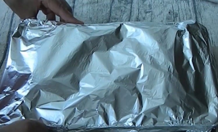 We cover the form with fish and vegetables with foil and send it to the oven.