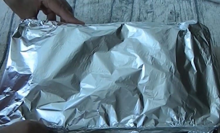 Cubrimos el formulario con pescado y verduras con papel de aluminio y lo enviamos al horno.