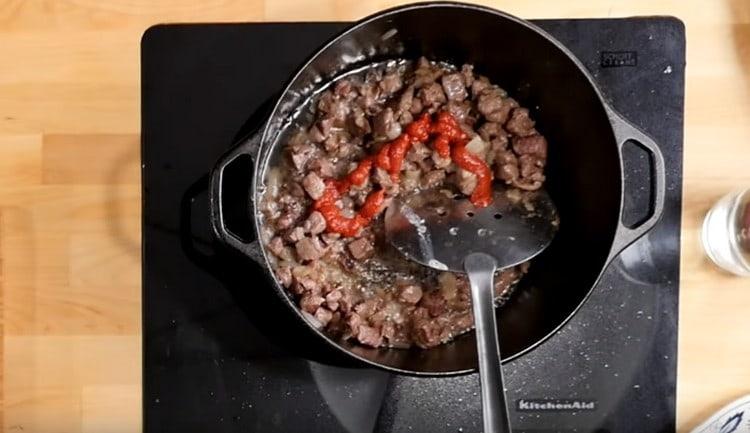 Ajouter la pâte de tomate à la viande avec des oignons.