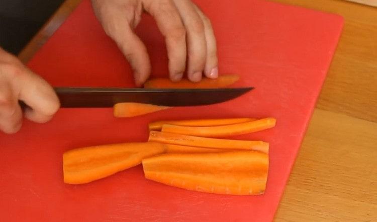Cortar las zanahorias en cubos. y las cebollas son medias aros.