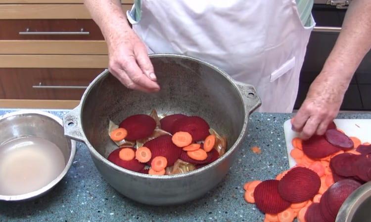 Au fond d'une grande casserole ou d'un chaudron, déposez les cosses d'oignon, puis les légumes.