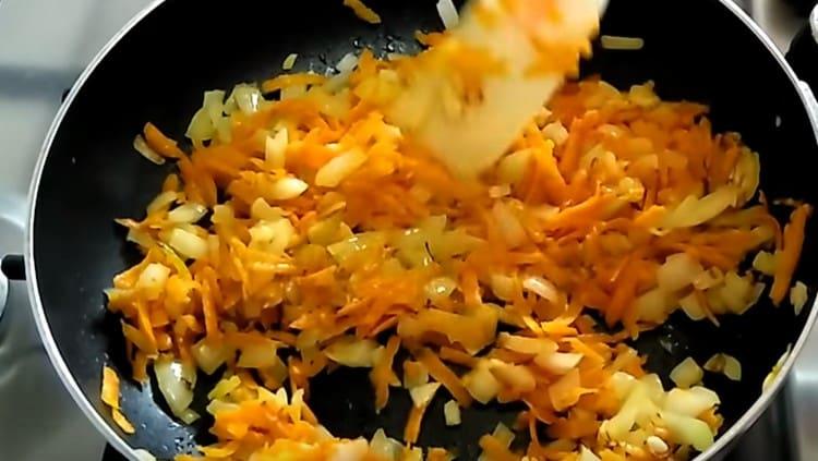 Faites frire les oignons avec les carottes jusqu'à ce qu'ils soient cuits dans une poêle.