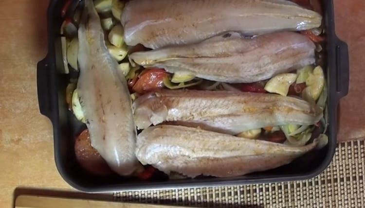 Nakon 10 minuta, ribu stavite na povrće i stavite u pećnicu.