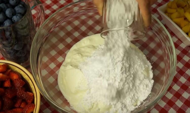 Agregue azúcar en polvo a la crema agria y mezcle.