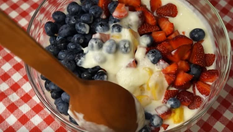 Now you can put all the prepared fruits into a sour cream mass.