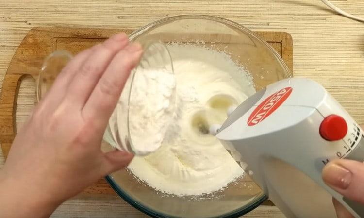 Agregue una mezcla de almidón y azúcar en polvo a la crema agria.