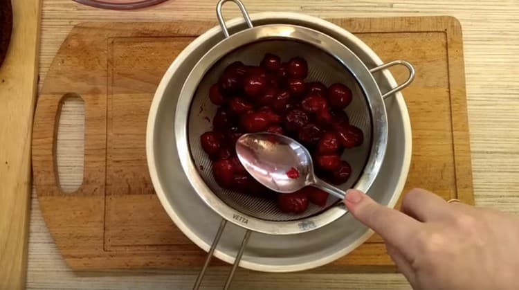 Inclina las cerezas sobre un tamiz para drenar el jugo.