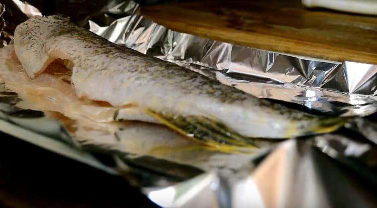 We cover the baking sheet with foil and put the pike carcass on it.