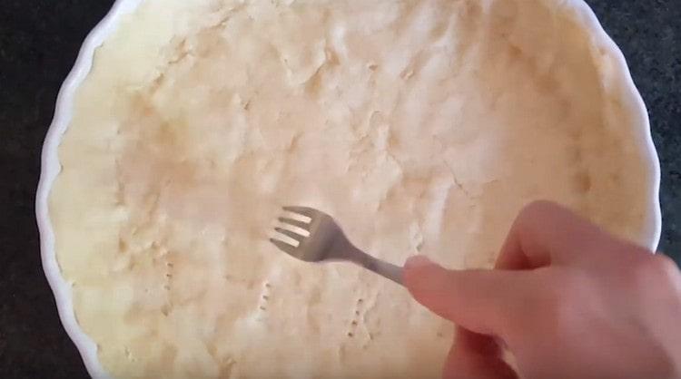 We spread the dough into a form, level it, make the sides and prick it with a fork.