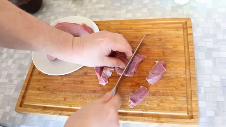 Pour cuire le bœuf dans des pots avec des pommes de terre au four, hachez la viande