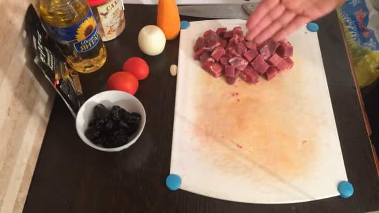 Para cocinar estofado de ternera con ciruelas pasas, picar la carne