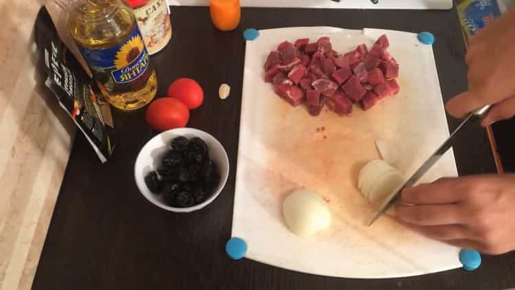 To cook beef stew with prunes, chop the onion