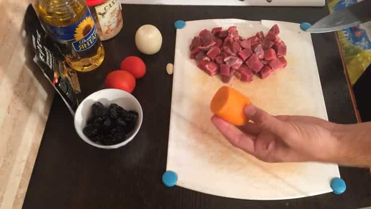 Para cocinar estofado de ternera con ciruelas pasas, pique las zanahorias