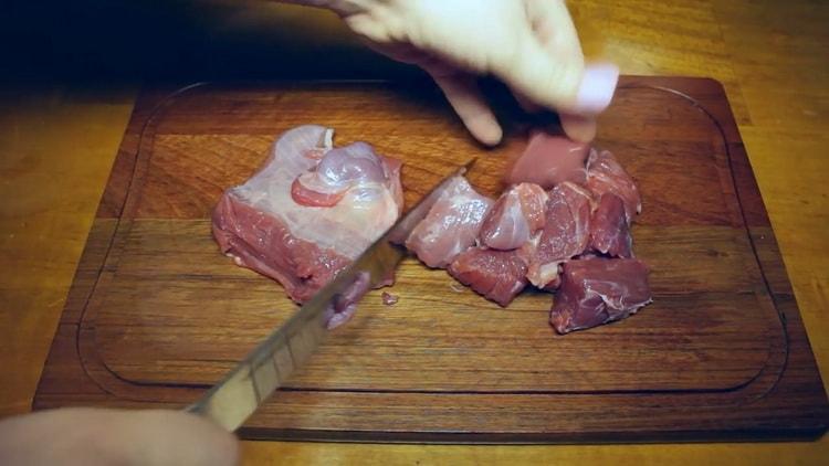 Para cocinar gulash de res en una olla de cocción lenta, corte la carne
