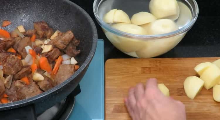 Pour la cuisson du rôti de boeuf avec des pommes de terre. hacher les pommes de terre