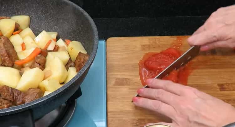 Pour la cuisson du rôti de boeuf avec des pommes de terre. hacher les tomates