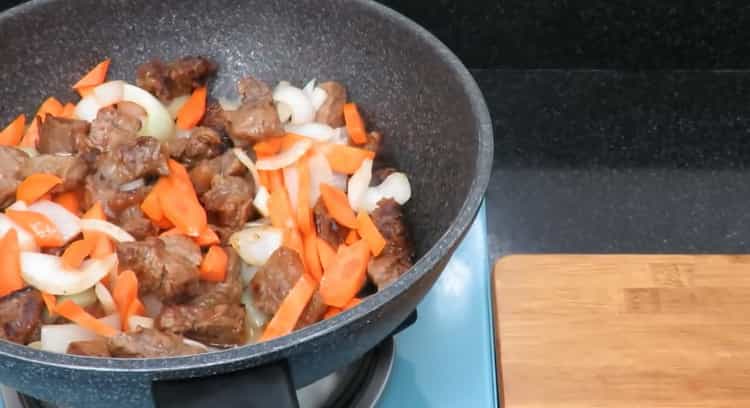 Pour la cuisson du rôti de boeuf avec des pommes de terre. faire frire les légumes et la viande