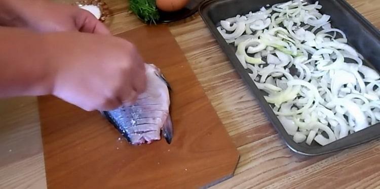 Para hacer carpa cruciana en crema agria, haga incisiones en el pescado