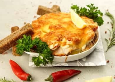 La receta de salmón chum bajo una capa de verduras con crema agria con una corteza de queso rojizo